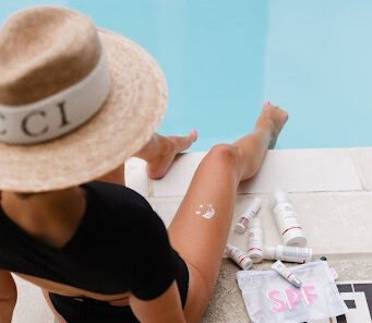 Woman drawing a smiley face with lotion on her leg.