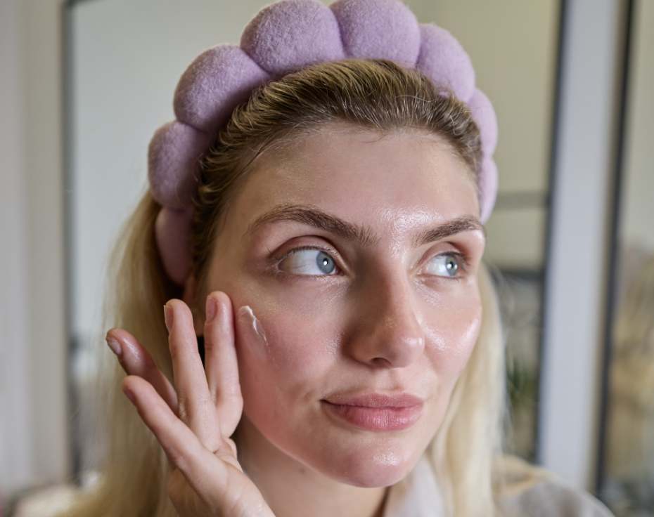 Woman applying cream to her face during winter.