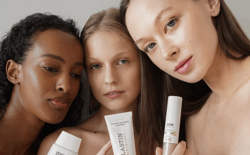 Three woman holding up skincare products